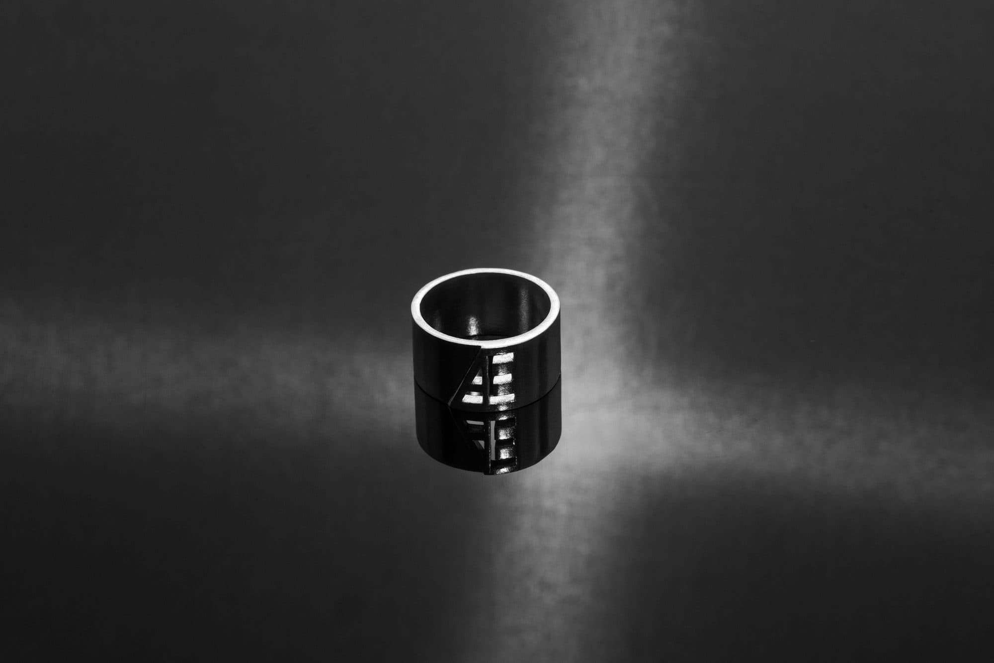 Silver monogram band lit by a single beam of light